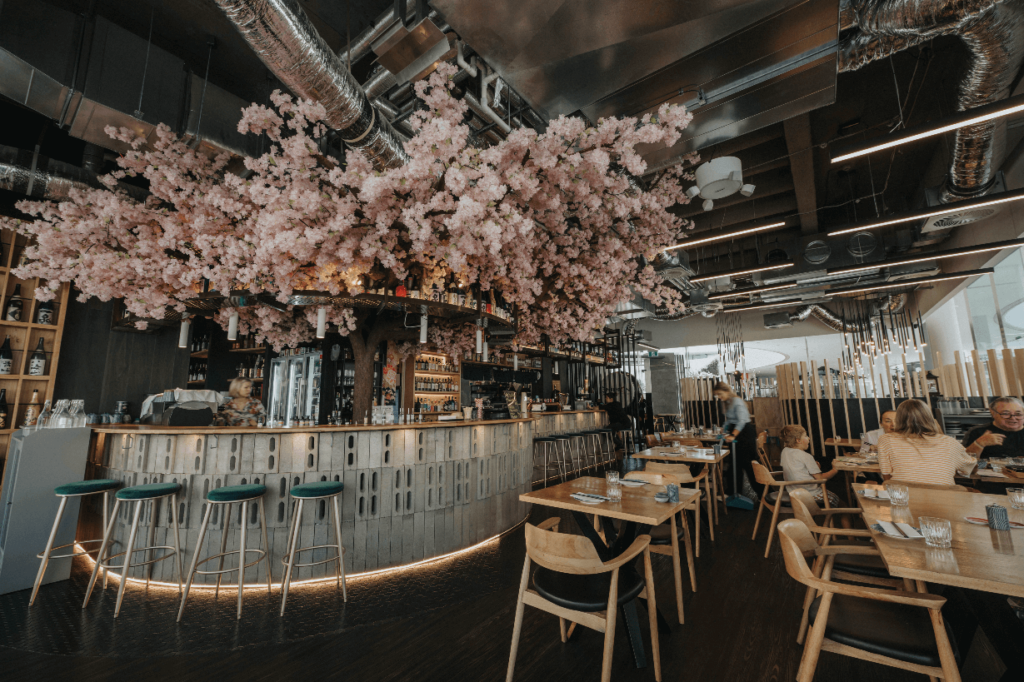 Japanese cherry blossum feature, timber flooring and welcoming dining area for this hospitality fit out for Nippon